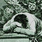 a man slumped on his desk, from 'The Sleep of Reason Produces
      Monsters'